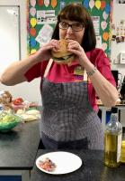 Lesley in her year as District Governor sampling the delicious burger cooked for her by the Young Carers